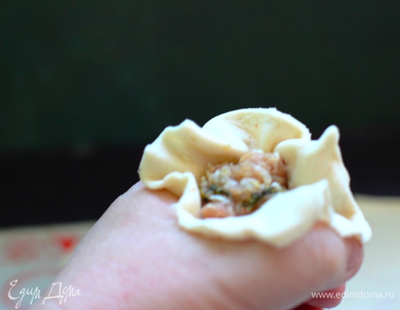 Кладем тесто с фаршем в ямку между большим и указательным пальцами. Вдавливаем начинку и тесто вниз, свободный край собираем в оборку вокруг начинки, как бы подпоясываем наш вонтон, склеивая оборку вокруг начинки. Если пальцы чуть липнут, окунаем в крахмал.