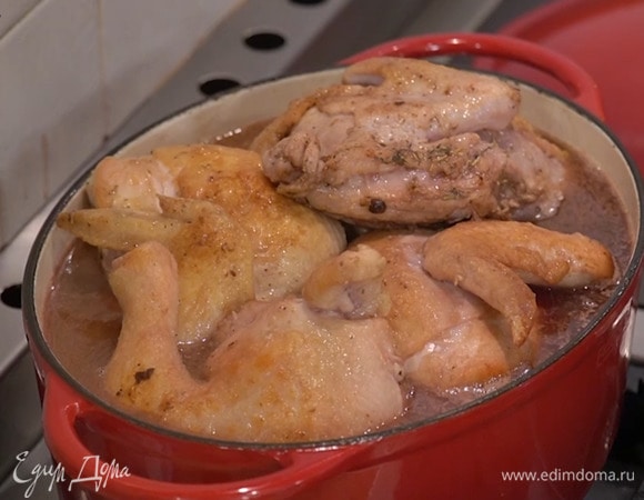 Влить в сотейник красное вино и прогреть его, затем добавить горячий куриный бульон, так чтобы цыплята были покрыты жидкостью, накрыть крышкой и готовить полтора-два часа, изредка переворачивая мясо.