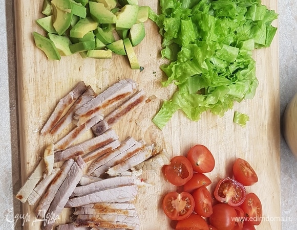 Листья салата нарезать, черри — на половинки, буженину — брусочками. Авокадо очистить от кожицы, удалить косточку. Каждую половинку разрезать на четвертинки и на ломтики.