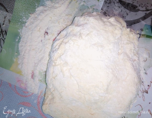 Выложить тесто на сухой стол, припорошенный мукой, и вымесить до однородности. Для данного процесса используем 3 горсти муки.
