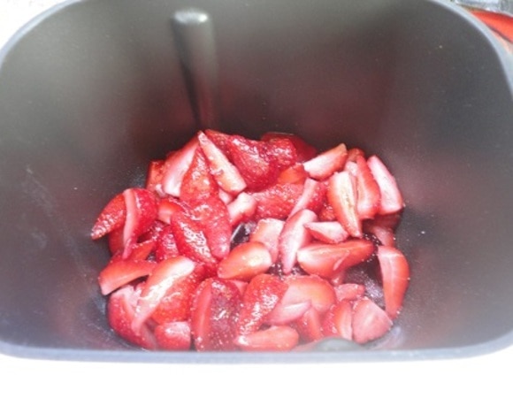 В форму хлебопечки выкладываем половину ягод, засыпаем половину сахара, смешанного с пектином.