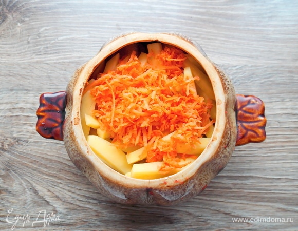 Морковку чистим, споласкиваем и натираем на мелкой терке. Добавляем в горшок и наливаем воду, закрываем крышкой.