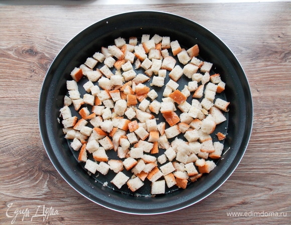 Батон режем на кусочки, добавляем тертый чеснок и поливаем растительным маслом, все аккуратно перемешиваем.