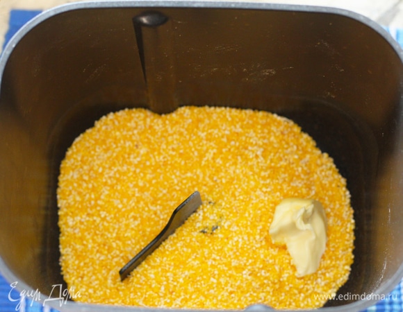 Специи класть необязательно, можете обойти их или положить сухой чеснок, петрушку, укроп, прованские сухие травы, паприку. Вскипятить воду. В дежу хлебопечи положить кукурузную крупу и все добавки, залить кипятком.