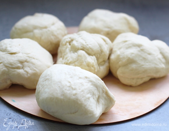 Выложить подошедшее тесто на посыпанную мукой рабочую поверхность, обмять и разделить на 6 частей.