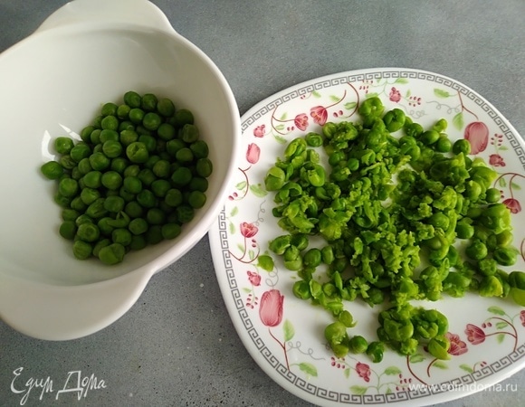 Зеленый горошек бланшировать, воду слить. Половину горошка размять вилкой. Вторую половину оставить целой.