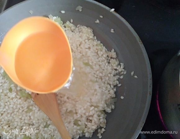 Когда вино выпарится, влить 2 половника горячего бульона, перемешать. Огонь средний. Готовить до выпаривания и снова влить 2 половника бульона.