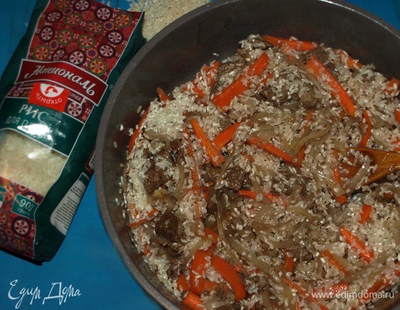 Добавляем рис для плова ТМ «Националь» к остальным ингредиентам и обжариваем 5 минут, постоянно помешивая. Каждое зернышко риса должно напитаться луково-мясным соком.