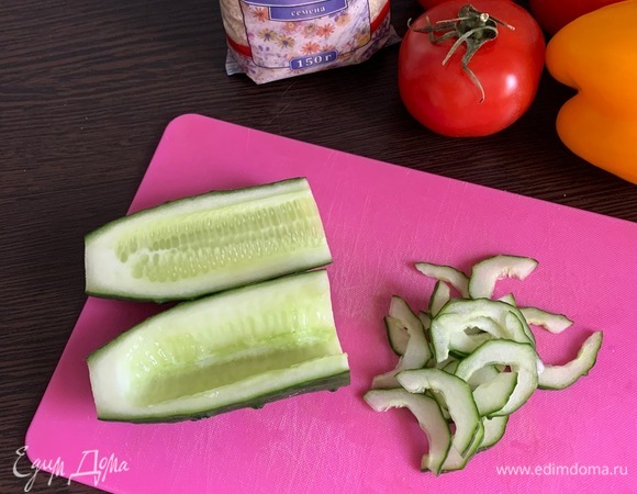 Огурец разрезаем вдоль пополам, ложкой удаляем семена, нарезаем тонкими ломтиками.