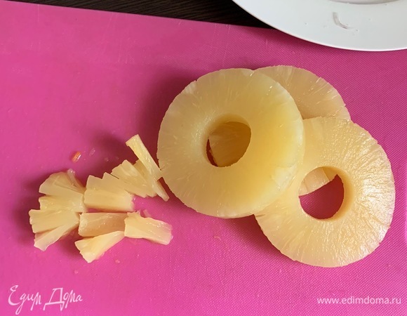Консервированный ананас (кольцами) откидываем на сито и мелко нарезаем.