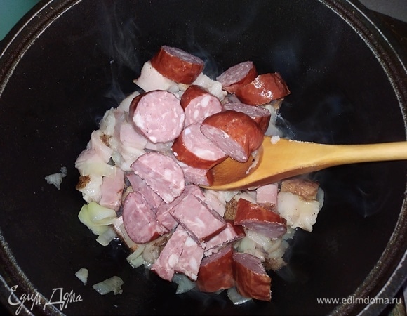Добавить нарезанную краковскую колбасу. Жарить вместе еще 5 минут.