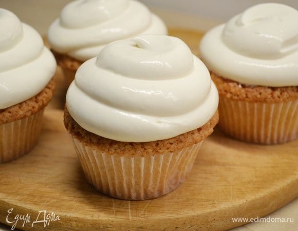 Холодные сливки, сыр и пудру взбить в пышную массу. Отсадить крем на капкейки.