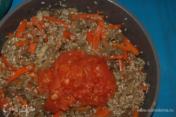 Добавляем измельченные помидоры. Перемешиваем и даем рису напитаться ароматом и вкусом томатов 2–3 минуты.