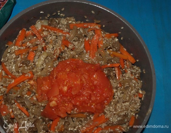 Добавляем измельченные помидоры. Перемешиваем и даем рису напитаться ароматом и вкусом томатов 2–3 минуты.