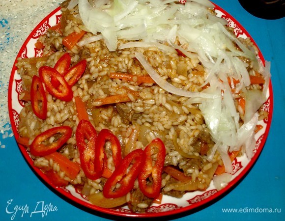 Шавлю подают на стол сразу с огня. Перекладываем шавлю в блюдо. Посыпаем по краям отбитым луком. Добавляем для остроты кружочки свежего острого перца.