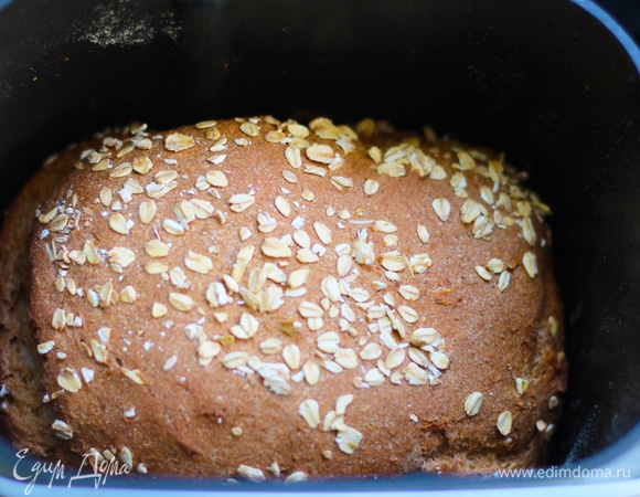 Перед началом выпекания смазать верхушку хлеба водой и посыпать овсянкой.