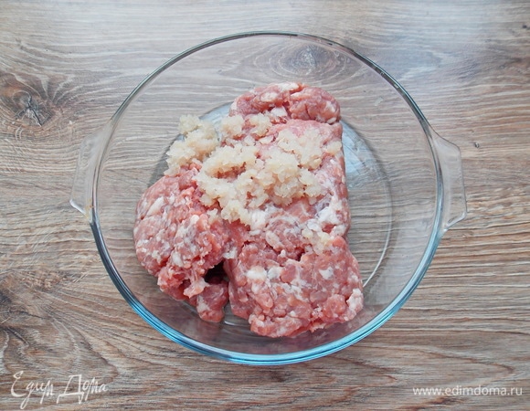 Положим в миску мясной фарш и репчатый лук, натертый на крупной терке.