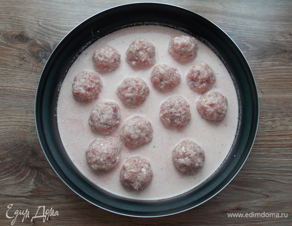 В форму для микроволновой печки выливаем соус. Фарш разделяем на части и скатываем тефтели. Чтобы они легче делались, смачивайте руки в воде.