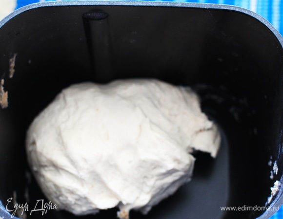 Тесто. В миску просеять 700 г муки. Добавить соль. Далее залить теплый кефир (воду) и размешать. Добавить соду (если готовите на воде, то сода не нужна). Замесить тесто сначала вилкой, потом — руками, по надобности можно подсыпать чуть муки. Я замешиваю в хлебопечке, режим «Пельмени» справляется прекрасно — тесто эластичное, глютен развит хорошо. Тесто должно быть нелипким. Делим тесто на 4 части (две побольше и две поменьше). Каждую скатываем в шар и под пленкой расстаиваем 20 минут.