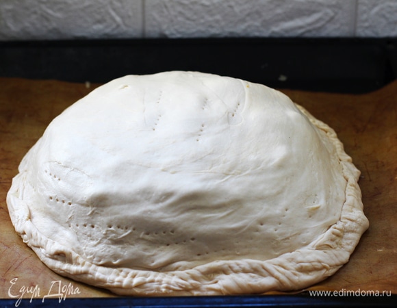 Так проделываем со следующими слоями. Завершаем пирог вторым большим пластом. Защипываем края, прижимаем их по борту вилкой. Вокруг защипа делаем несколько наколов вилкой, чтоб выходил пар и донышко не дало течь. Верх пирога также прокалываем в нескольких местах. Смазываем остатком масла.