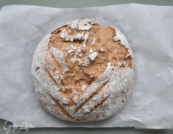 Сформировать буханку, посыпать ее мукой и оставить на 30 минут для подъема. Выпекать хлеб в разогретой до 240°C духовке 15 минут с паром. Затем температуру уменьшить до 200°C и выпекать еще 30 минут без пара. Остудить хлеб на решетке.