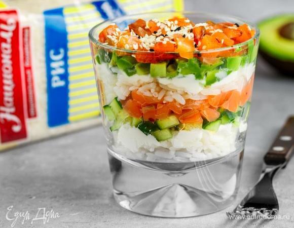 Укладываем слоями в стакан ингредиенты в следующем порядке: рис, творожный сыр, огурец, лосось, рис, творожный сыр, авокадо, лосось. Сверху посыпать белым и черным кунжутом. При подаче полить соевым соусом.