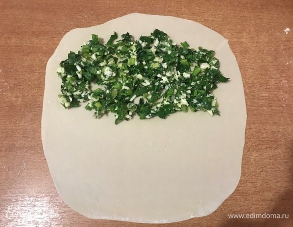 Готовое тесто разделить на 10 частей. Каждый кусочек раскатать в тонкую лепешку. Положить на одну половину лепешки немного начинки и равномерно ее распределить.