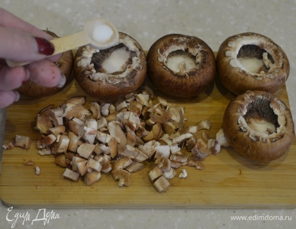 Аккуратно удалите ножки у грибов. Нарежьте ножки мелким кубиком.