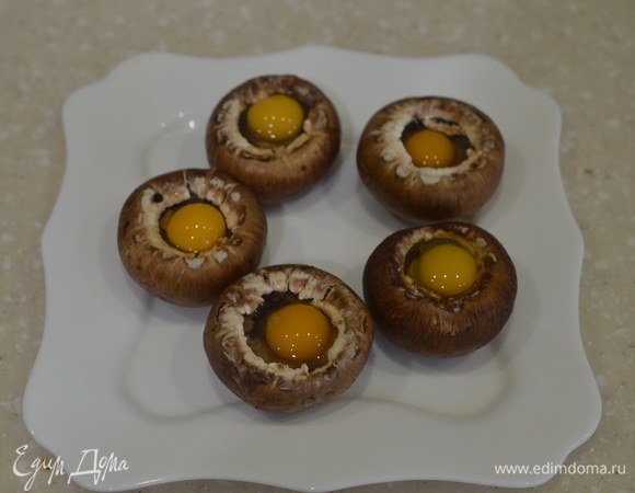 Каждую шляпку посолите и аккуратно вбейте в них по перепелиному яйцу.