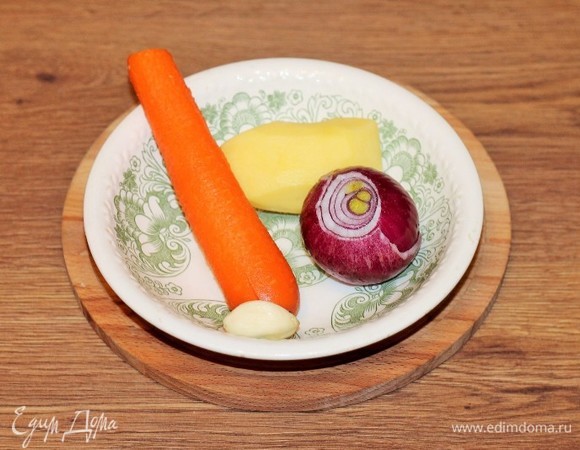 За это время подготовим овощи и зелень. Репчатый лук, морковь, картофель, чеснок очищаем от кожуры и шелухи, у перца чили отрезаем плодоножку и удаляем семена. Промываем листья мяты и кориандра.