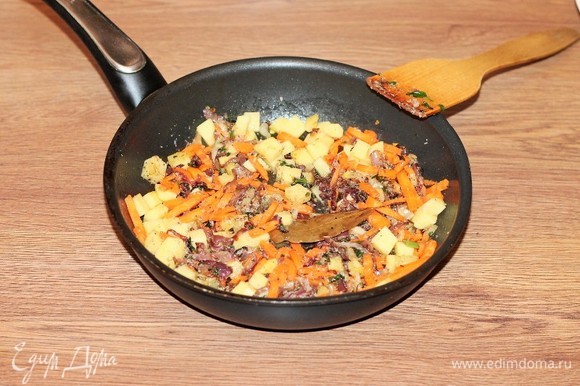 Затем добавляем картофель и морковь и на слабом огне тушим овощи под крышкой до полуготовности. Если недостаточно масла, добавьте 1–2 ст. л. воды.