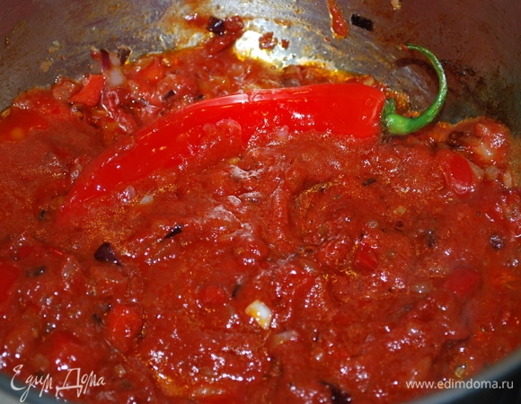К обжаренному луку добавьте томатную пасту, немного сахара, обжарьте все вместе 1–2 минуты и добавьте протертую мякоть томатов.