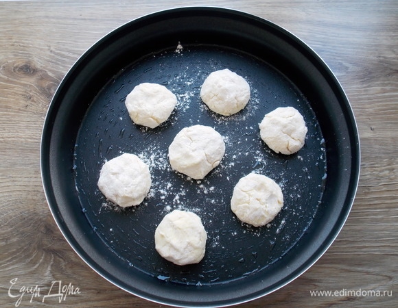 Обваливаем творожную массу в муке и делаем колобки. Форму для микроволновой печки смазываем растительным маслом, но можно обойтись и без этого.