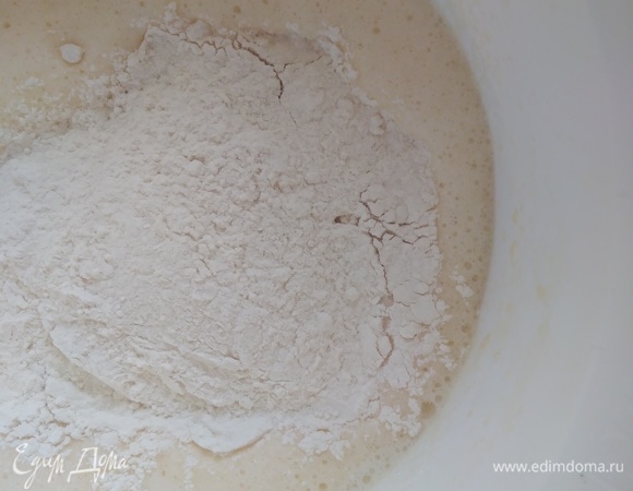 Влить половину молока (немного подогреть) и всю муку. Взбить миксером.