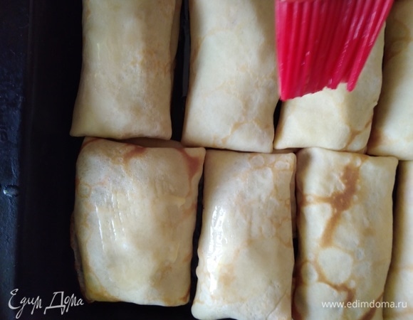 Блинчики поместить на противень. Духовку разогреть до 180°C. Смазать каждый блин растопленным сливочным маслом. Запекать 20 минут.