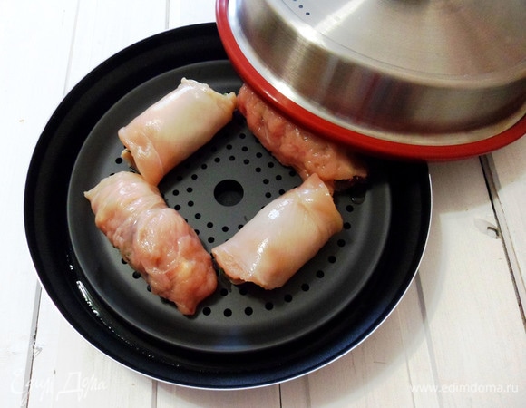 В емкость комплекта Steam Plus Pot налить 300 мл воды. Установить подставку для варки на пару и выложить на нее рулетики и закрыть крышкой.