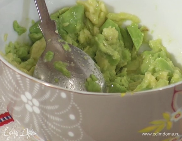 Авокадо разрезать пополам и удалить косточку, ложкой вынуть мякоть и выложить в глубокую пиалу, влить оливковое масло, сок лимона, посолить и размять.