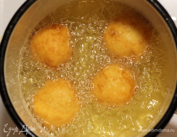 В сотейнике или любой кастрюльке с толстым дном разогреваем растительное масло, жарим пончики на среднем огне минуты 3–4 до золотистого цвета. В процессе жарки переворачиваем, чтобы равномерно пропеклись. Готовые пончики выкладываем на бумажное полотенце или салфетки, чтобы впиталось лишнее масло.