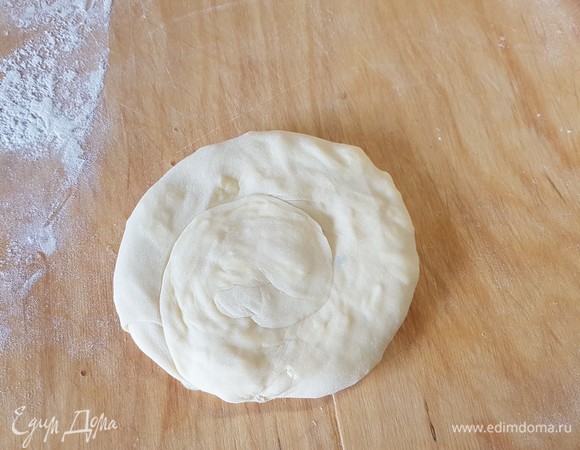 Скрутить в рулет, а потом закрутить в «улитку». Немного раскатать лепешку.