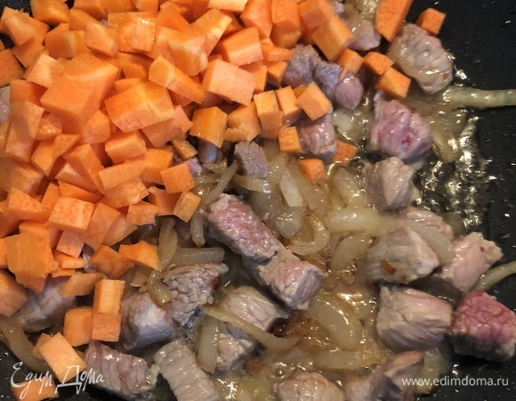 Половинку морковки нарезаем кубиками и добавляем к мясу с луком. Тушим на слабом огне 5–7 минут, солим и добавляем специи по вкусу.