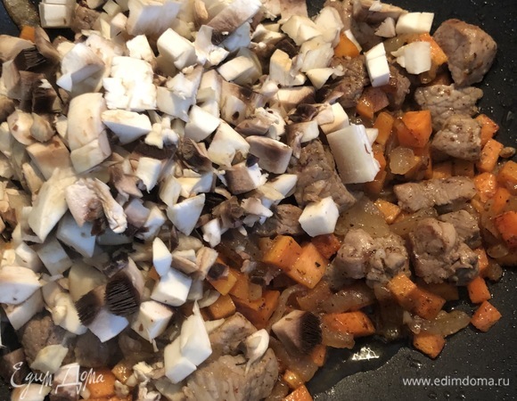 Следующий этап — грибы. У меня крупные шампиньоны. Один оставляем на потом, остальные режем кубиками и добавляем в сковороду.