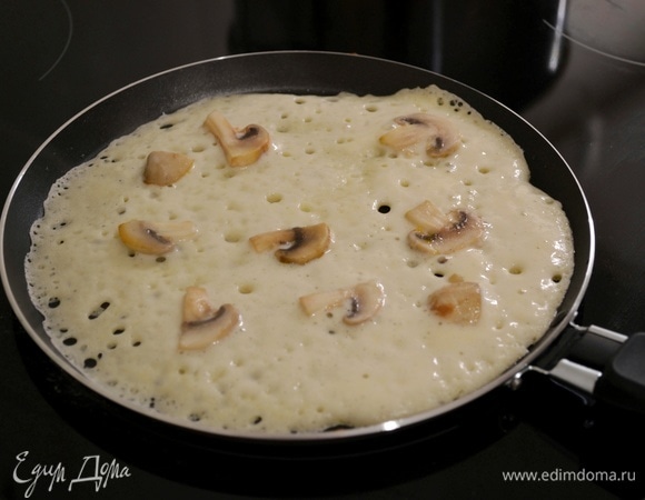 Грибы нарезать на ломтики и обжарить до полуготовности на небольшом количестве масла. Горячую сковороду смазать растительным маслом, налить половник теста и распределить кусочки грибов сверху. Жарить с двух сторон до золотистости. Каждый готовый блин смазать сливочным маслом.