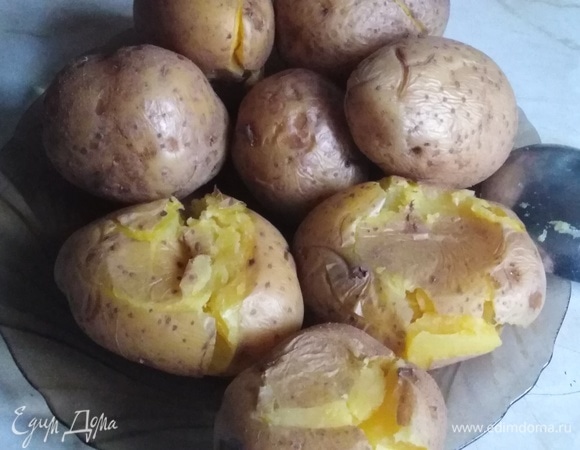 Отварной в мундире картофель примять ложкой, стараясь не допустить разлома картошки.