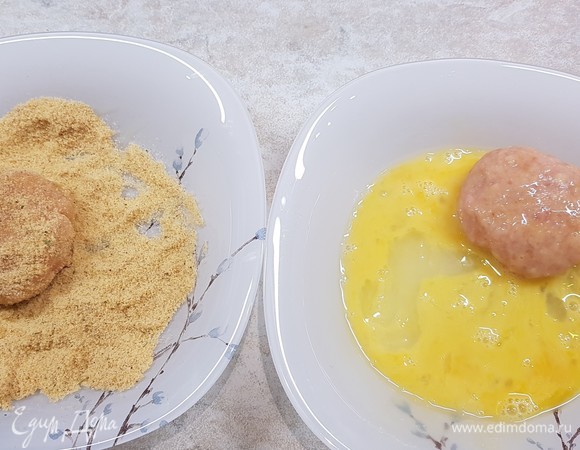 Из фарша сформировать плоские котлеты. Сначала обмакнуть в яйцо, а потом обвалять в панировочных сухарях.