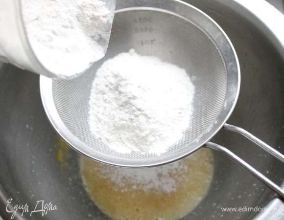 Добавляем просеянную муку и разрыхлитель, все тщательно перемешиваем.