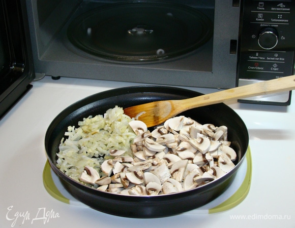 К луку добавить нашинкованные грибы, перемешать и обжарить на полной мощности (1000 Вт) в течение 10 минут.