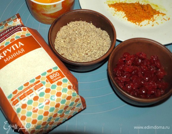 Миндаль обжарить и измельчить в мелкую крошку. Вяленую вишню хорошо промыть, отжать, разрезать на две половинки. С апельсина снять цедру, яйца разделить на белок и желток. Белок поставить в холодильник (он нам не понадобится).