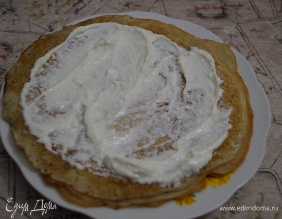 Для такого количества творожного крема возьмите три блина, разогрейте их в микроволновке 1,5 минуты и по очереди намажьте творожным кремом.