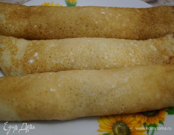 Смазанные кремом блины сверните в трубочки, уложите на подходящее блюдо.