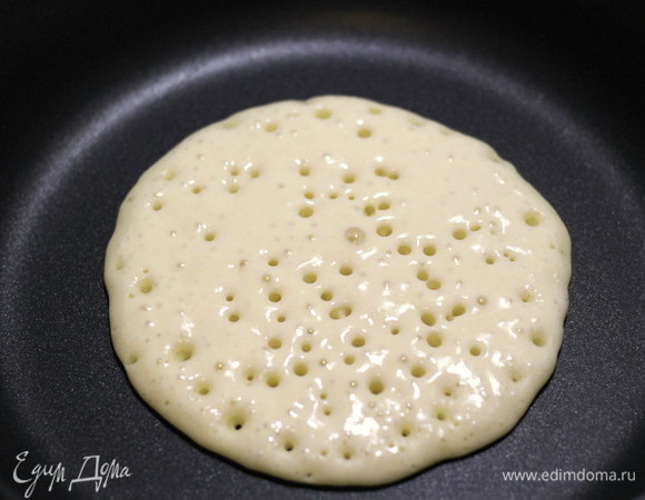 Хорошо разогреть сковороду, ничем ее предварительно не смазывая. В центр наливаем 3 ст. л. теста. Слегка разглаживаем ложкой блинчик, чтобы был круглым. Жарим до тех пор, пока блин не покроется дырочками, а его поверхность не будет сухой.